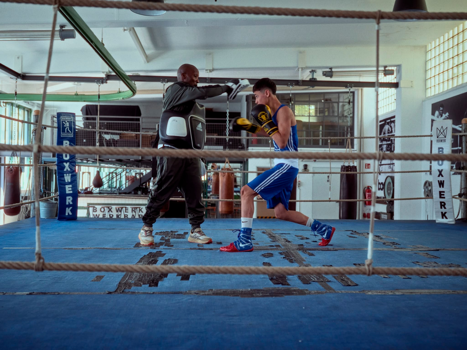 Coach Walu holding pads for Sorela in the ring at Boxwerk Munich