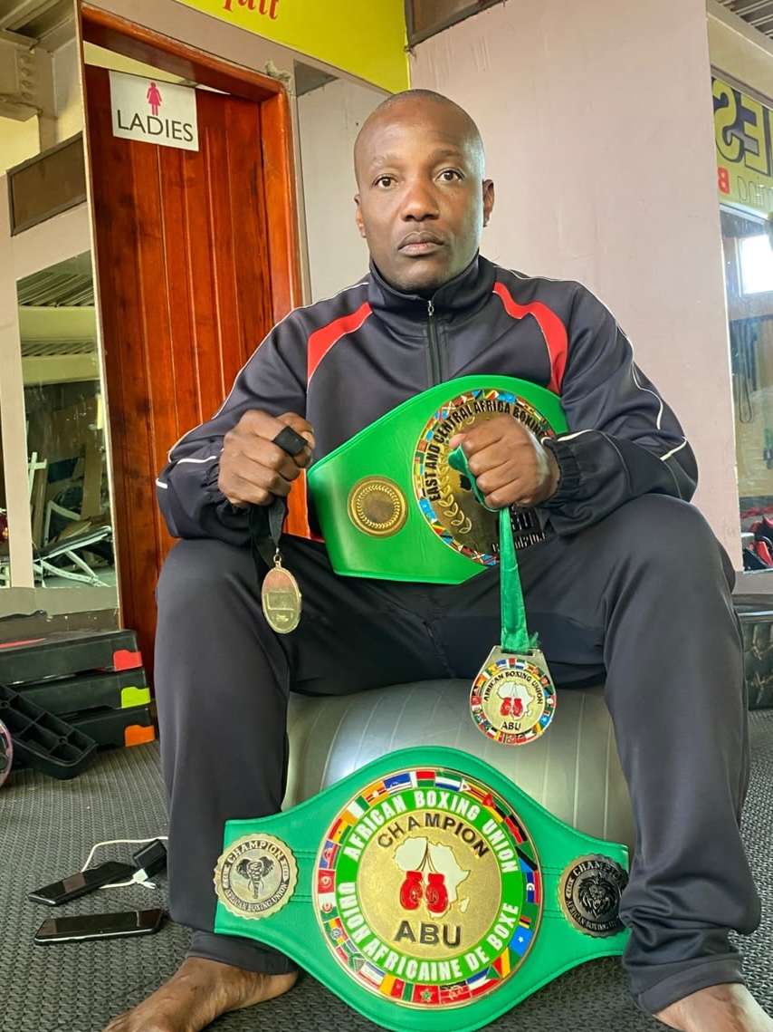 Coach Walu with African Boxing Union and East and Central Africa championship belts