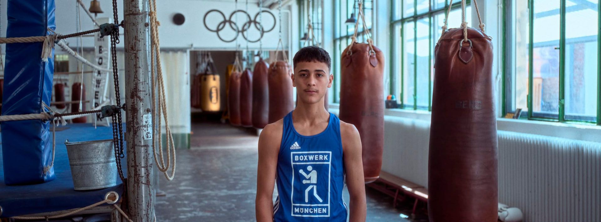 A young boxer in a Boxwerk München vest at the gym