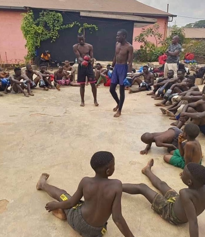 Young boxers gathered in a circle for an open-air training session in Uganda